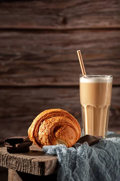 Frisch gebackenes duftendes Croissant mit Kakao im Glas auf Holzgrund — Stockfoto