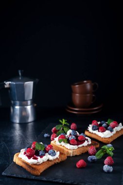 Peynirli, reçelli, taze ahududu ve yabanmersinli taze bruschetta.