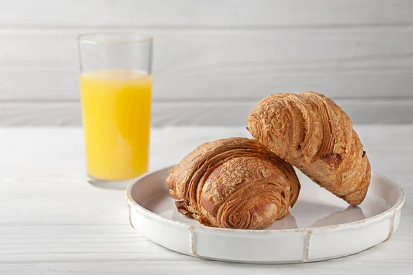 Croissants fraîchement cuits avec du jus d'orange fraîchement pressé. Petit déjeuner européen. — Photo