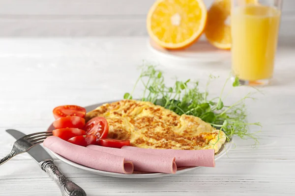 Ein leichtes Frühstück mit französischen Omelettes mit Wurst, Tomaten und Mikrogemüse. Europäisches Frühstück — Stockfoto