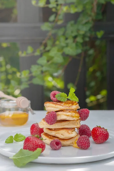 Healthy breakfast. Pancakes with forest fruits berries on white table.