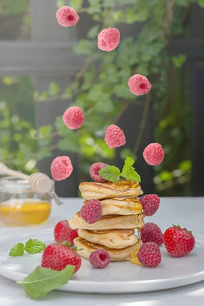 Healthy breakfast. Pancakes with forest fruits berries on white table.