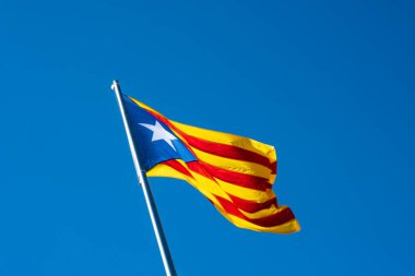 Senyera Estelada bayrağı, sarı bir alanda dört kırmızı şerit ve solunda bir yıldız bulunan mavi üçgen, İspanyol devleti ile özerk Katalonya halkının bağımsızlık iddiasının sembolü..