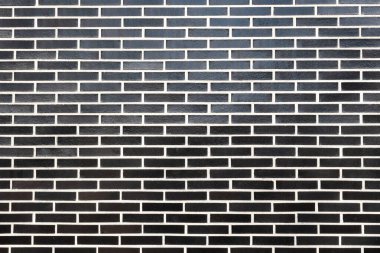 Beyaz harçlı, yatay oryantasyonlu siyah tuğla bir duvar dokusu. Farklı amaçlar için kusursuz arkaplan, metin için alanı kopyala.