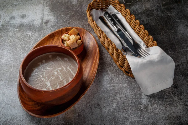 灰色の石のテーブルにパンくずとトレイ上の木製のボウルにキノコスープをマッシュ — ストック写真
