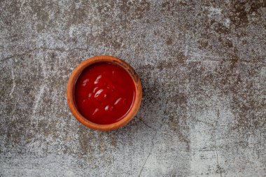 Tomato sauce in a sauce pot on a restaurant stone table