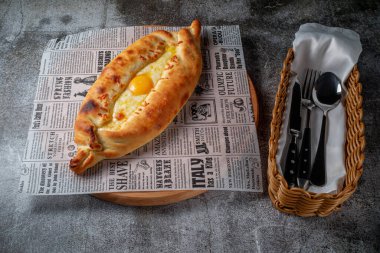 Khachapuri on Adjarian with egg. Traditional tortillas with eggs of Georgian cuisine. Eastern food. Restaurant service.