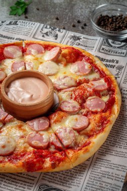 Fresh delicious Italian pizza with sauce in the background of a gray stone table