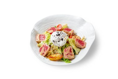 Kavrulmuş ton balığı salatası, kırmızı soğan, taze vişneli domates ve beyaz izole edilmiş bir arka planda sulu portakal sosu.. 