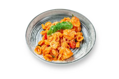 Domates ve peynirli İtalyan makarnası, beyaz izole arkaplanda bir tabakta fesleğen. Kopyalamak için yer var. Üst görünüm.