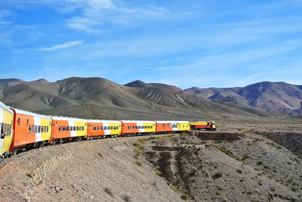 Kleurrijke trein cruisen een berglandschap — Stockfoto