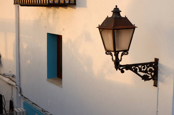 Old vintage lantern on the wall downtown in Peniscola, Valencian community, Spain