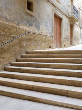 İspanyol köyü Calaceite, Teruel, Aragon, İspanya 'daki boş, sessiz bir dar sokağa giden klasik merdivenler. Dikey fotoğraf.
