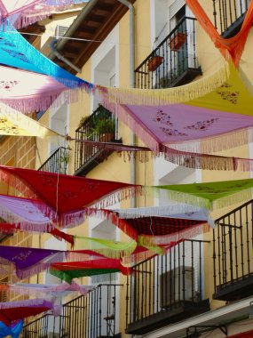 Madrid 'in Madrid şehir merkezindeki La Latina semtindeki Madrid gününde renkli şallar dışarıda takılıyor..