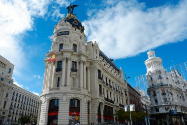 Madrid, İspanya - 27 Kasım 2021: Gündüz manzarası. Metropolis adlı klasik tarihi binanın kulesi. Fransız mimarlar Jules ve Raymond Fevrier tarafından 20. yüzyılın başlarında inşa edildi.
