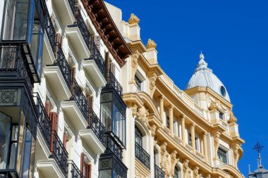 Madrid, İspanya 'nın merkezinde klasik pencere ve balkonları olan renkli cepheler. Şehir merkezindeki eski moda İspanyol mimarisi.