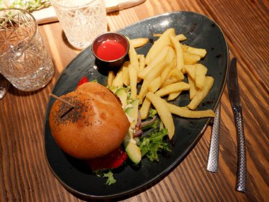 Sebze soslu vejetaryen hamburger, sıcak restorandaki tabakta patates ve domates sosu..