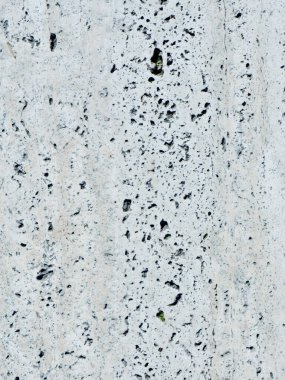 Arkaplan ve arkaplan olarak gri çatlakları olan düz beyaz bir taş. Dikey fotoğraf.