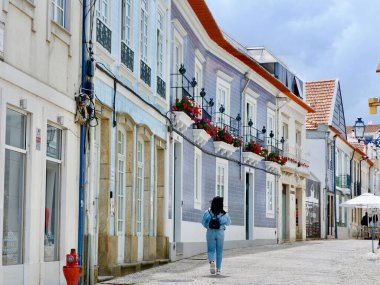 Aveiro, Portugal - May 16, 2022: daily life on the cozy colourful street downtown the city. Elegant portuguese architecture.