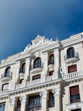 Beige classical facade of building in central district downtown Madrid, Spain. Vertical photo.