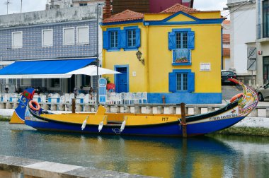 Aveiro, Portekiz - 16 Mayıs 2022: Geleneksel Moliceiro gondol gemisi şehir merkezindeki nehir kanalına yanaştı.