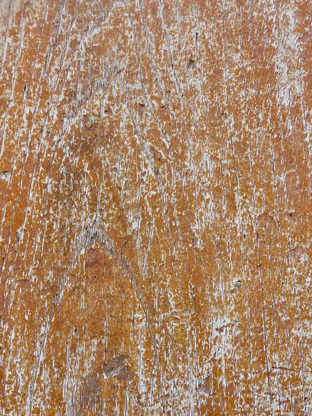 Weathered wood background with peeling orange paint