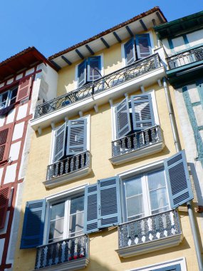 Retro colourful buildings with old fashioned windows and balconies on the street downtown Bayonne, Basque country, France. Vertical photo.