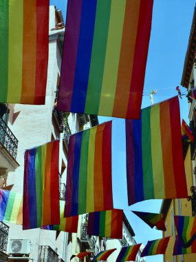 Gay topluluğunun birçok gökkuşağı bayrağı Madrid sokaklarında asılıdır. Gurur günlerinde, Chueca Bölgesi, İspanya.