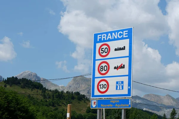 Nouvelle-Aquitaine region, France - August 07, 2022: Road sign with speed limits at the entrance to the country with picturesque mountain background.