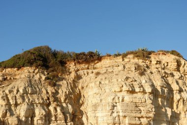 Güneşli bir günde Portekiz 'in Algarve bölgesindeki Lagos' ta kayalar mavi gökyüzüne karşı kayalar..