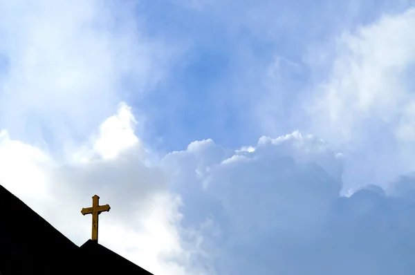 Cruz en una iglesia enfrenta el cielo y las nubes — Foto de Stock