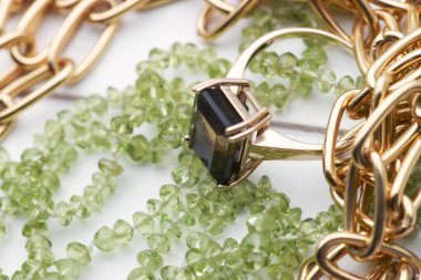 altın kolye ve yüzük ile yeşil peridot boncuk kolye