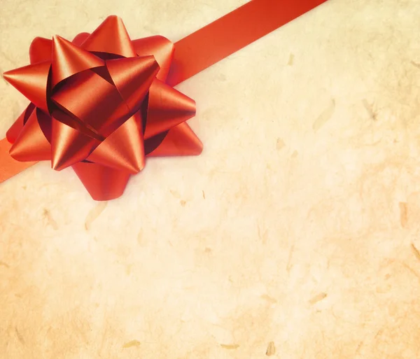 Red gift bow with old paper — Stock Photo, Image