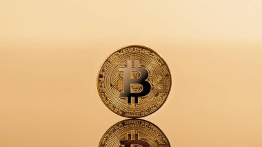 Yansıması ve sarı arkaplanı olan bitcoin kripto para birimi.