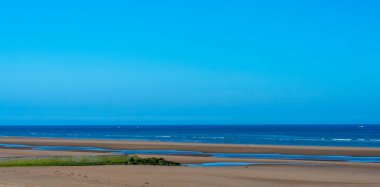Image with sand of beach, ocean and sky in totally clear background.