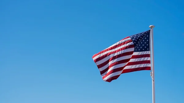 Image with American flag with clear blue sky.
