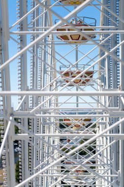 Image with white structure from Ferris wheel itself in amusement park.