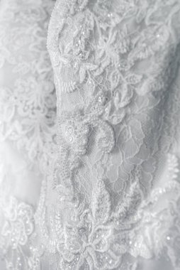 Gelinlik kumaşının ayrıntıları ve çizimler ve metin için arka plan olarak kullanılan güzel işlemeli düğün konsepti..