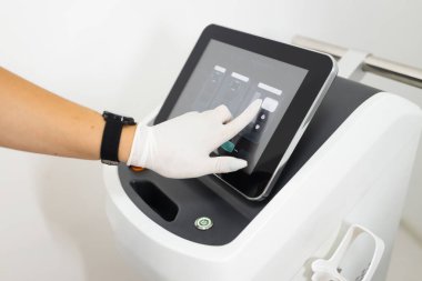 Doktorun eli lazeri epilasyona ayarlar.