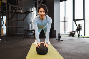 Spor salonunda tıp topuyla jimnastik yapan güzel bir kadın. Trx egzersizi 
