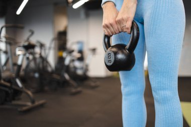 Kettlebell tutan kadın. Yakından.