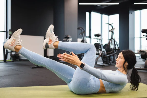 Karın kasları çalıştıran bayan sporcu mekik çekiyor.