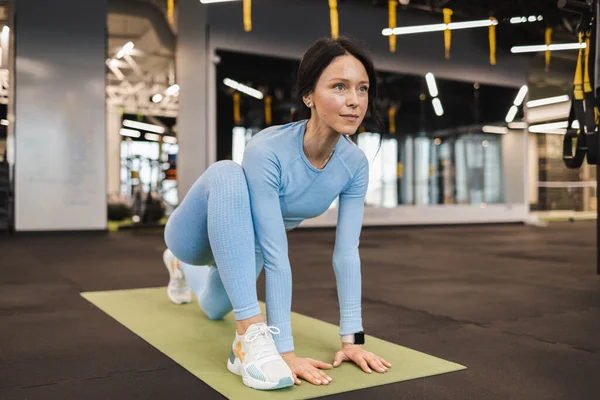 Spor salonunda esneme hareketleri yapan bir kadın. Pilates egzersizi