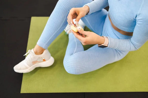 Fitness Woman Sitting Mat Pulls Out Wireless Headphones Charging Case — 图库照片