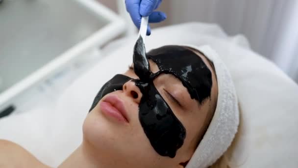 Cosmetólogo Aplicando Máscara Negra Cara Mujer Salón Spa Procedimiento Rejuvenecimiento — Vídeos de Stock