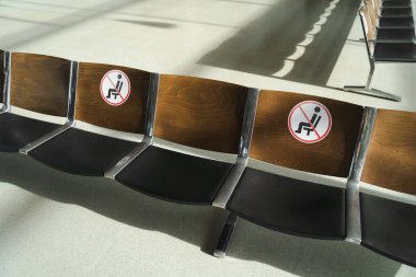Empty waiting chairs with social distancing sign. Prevention of coronavirus infection concept