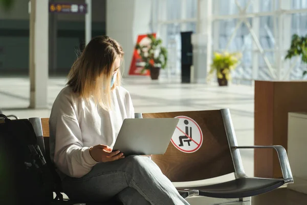 Female Tourist Sitting Airport Lobby Chair Social Distancing Sign Using — Stockfoto