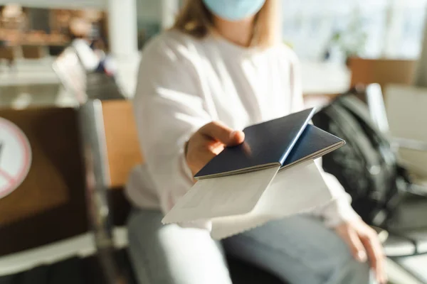 Woman Mask Sits Waiting Room Holds Out Her Passport Ticket — Stockfoto