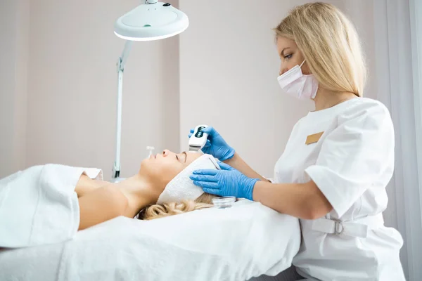 Doctor Cosmetologist Makes Professional Ultrasound Cleaning Facial Skin Beautiful Woman — Fotografia de Stock
