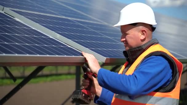 ソーラーパネルの設置プロセス 発電所で電気レンチを使用する技術者労働者 — ストック動画